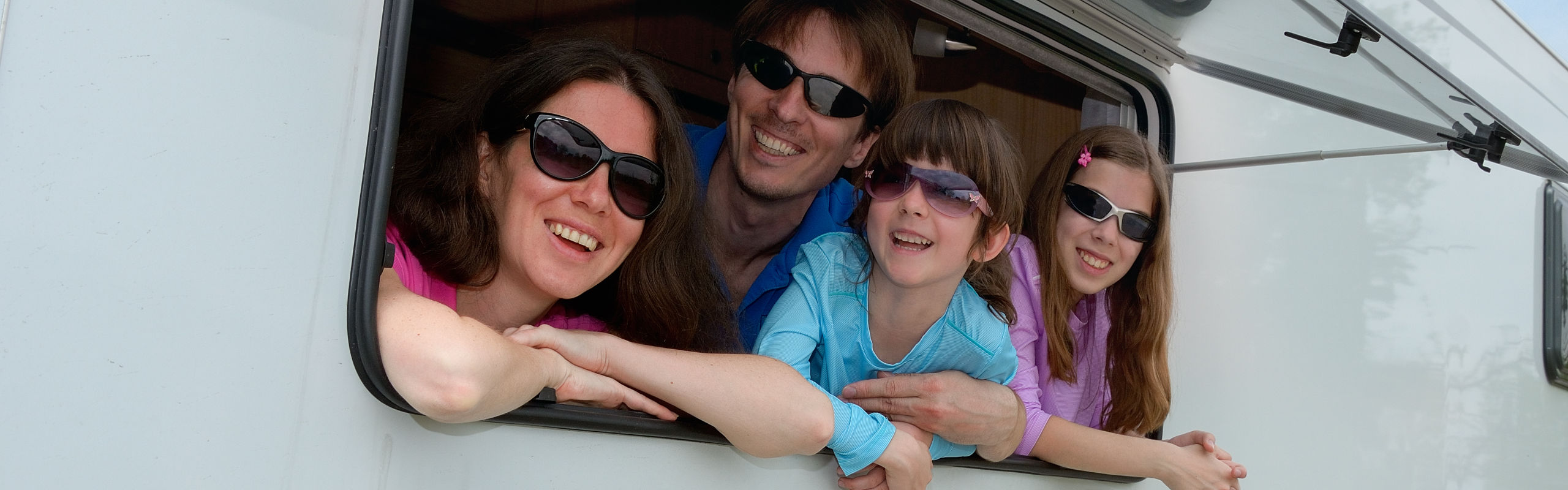 Family looking out of the window in their holiday caravan